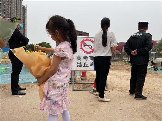 有小女孩拿着花在门口外等候还在高考的哥哥姐姐。 澎湃新闻记者 吴怡 图